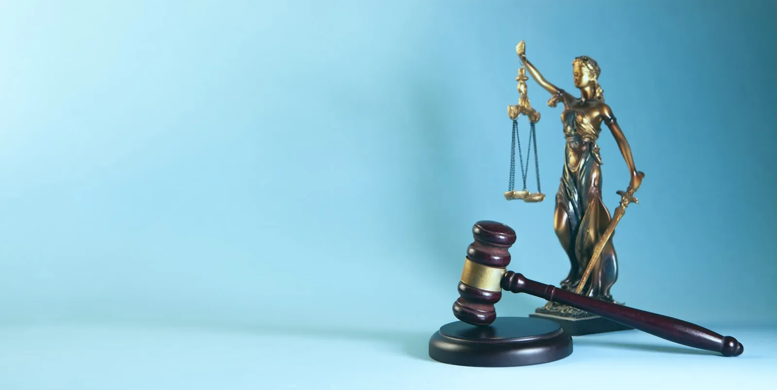 Lady Justice statue and a wooden gavel symbolizing legal proceedings