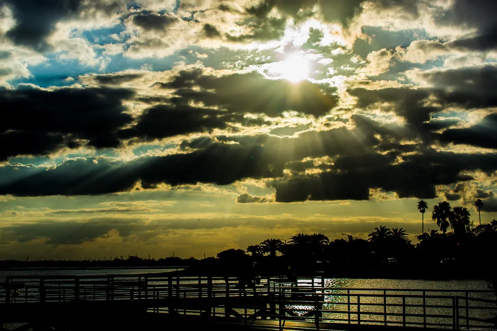 Sun rays over Lake Tohopekaliga in Kissimmee, Florida with palm tree silhouettes